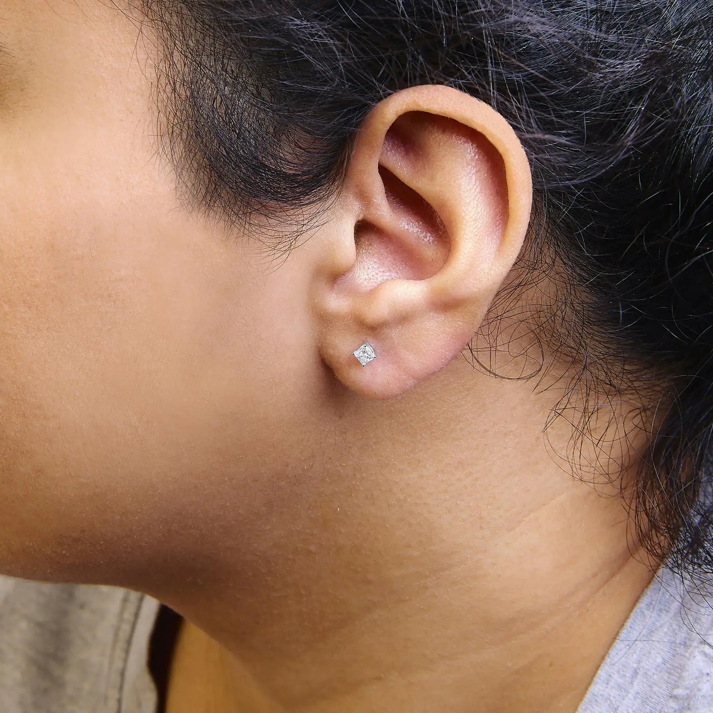 Model wearing 14K white gold princess cut lab-grown diamond solitaire stud earrings.