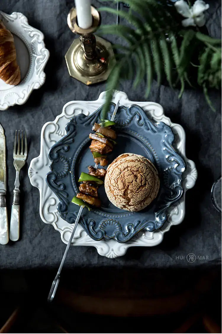 Exquisite Baroque dining set featuring a unique blue plate with skewered vegetables and a bread roll.