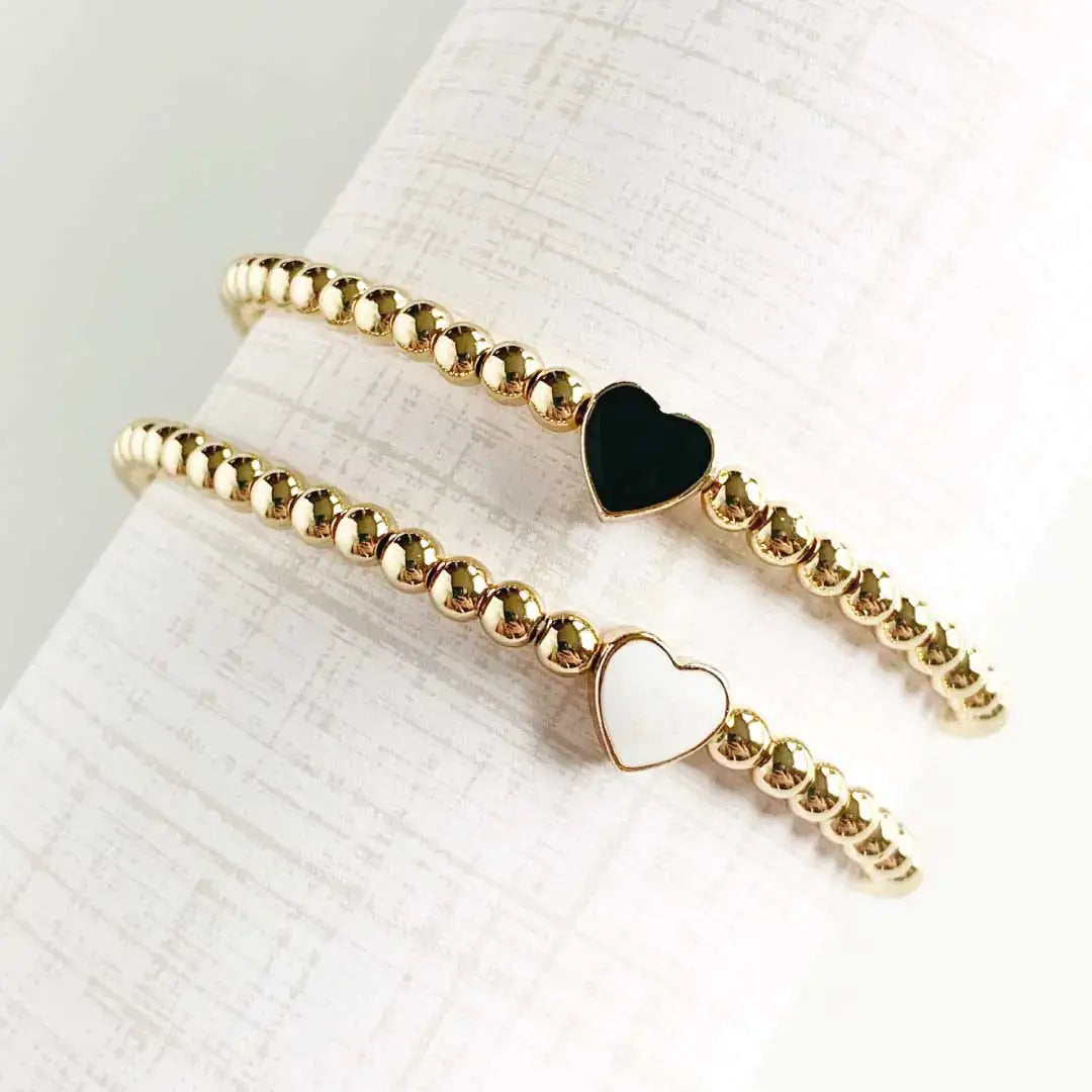 Elegant heart gold bead bracelets featuring black and white hearts, perfect for stylish layering or gifting.