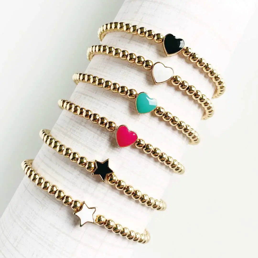 Elegant gold bead bracelets featuring colorful hearts and stars in pink, black, teal, and white, perfect for versatile styling.