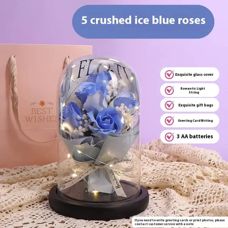 Elegant display of 5 crushed ice blue roses under glass dome with LED lighting and gift packaging.