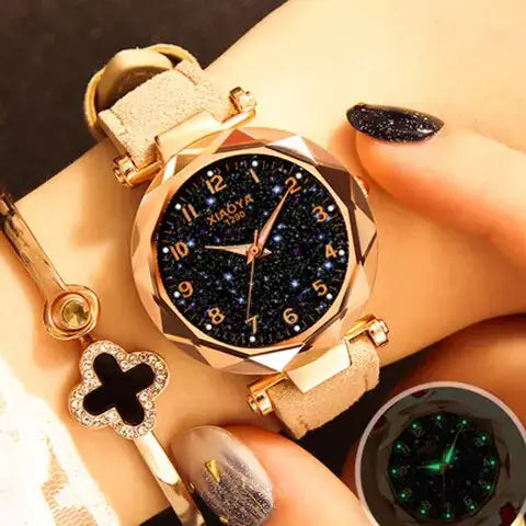 Quartz women's watch with luminous starry design on wrist, featuring a gold-tone case and a black starry dial.