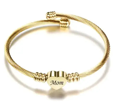 Gold stainless steel braided bracelet with heart-shaped 'Mom' charm, ideal Mother's Day gift.