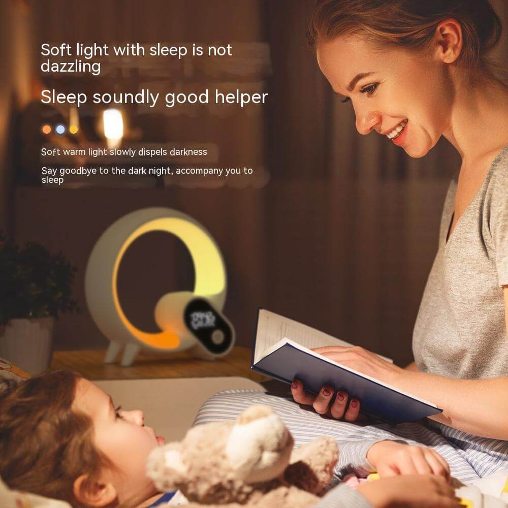 Mother reading to child beside Q Light alarm clock offering soft light for peaceful sleep.