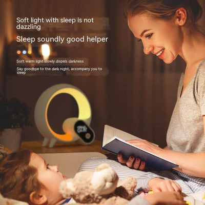 Mother reading to child beside Q Light alarm clock offering soft light for peaceful sleep.