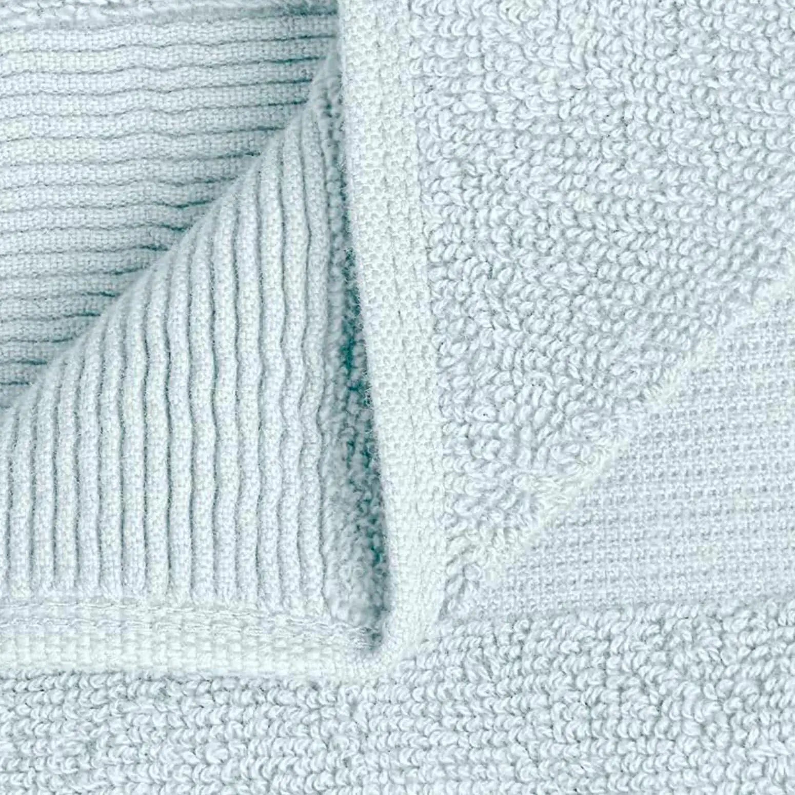 Close-up of light blue bath towel fabric showcasing its plush texture and ribbed design features.