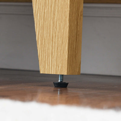 Close-up of the sturdy oak leg with adjustable screw base for the wooden antique dresser cabinet.