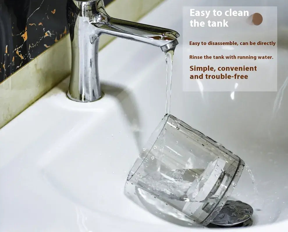 Water flowing from a faucet into a clear container, demonstrating easy cleaning of the tank.