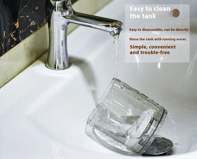 Water flowing from a faucet into a clear container, demonstrating easy cleaning of the tank.