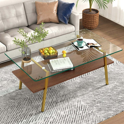 Modern rectangle coffee table with tempered glass top and gold metal legs in a stylish living room setting.