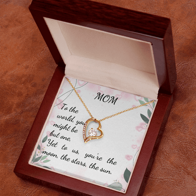 Gold heart pendant necklace on floral card inside gift box for Mom, featuring a crystal and heartfelt message.