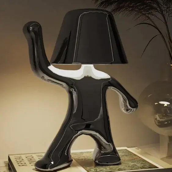 Sleek black LED night lamp in a unique human shape, providing stylish illumination for modern decor.