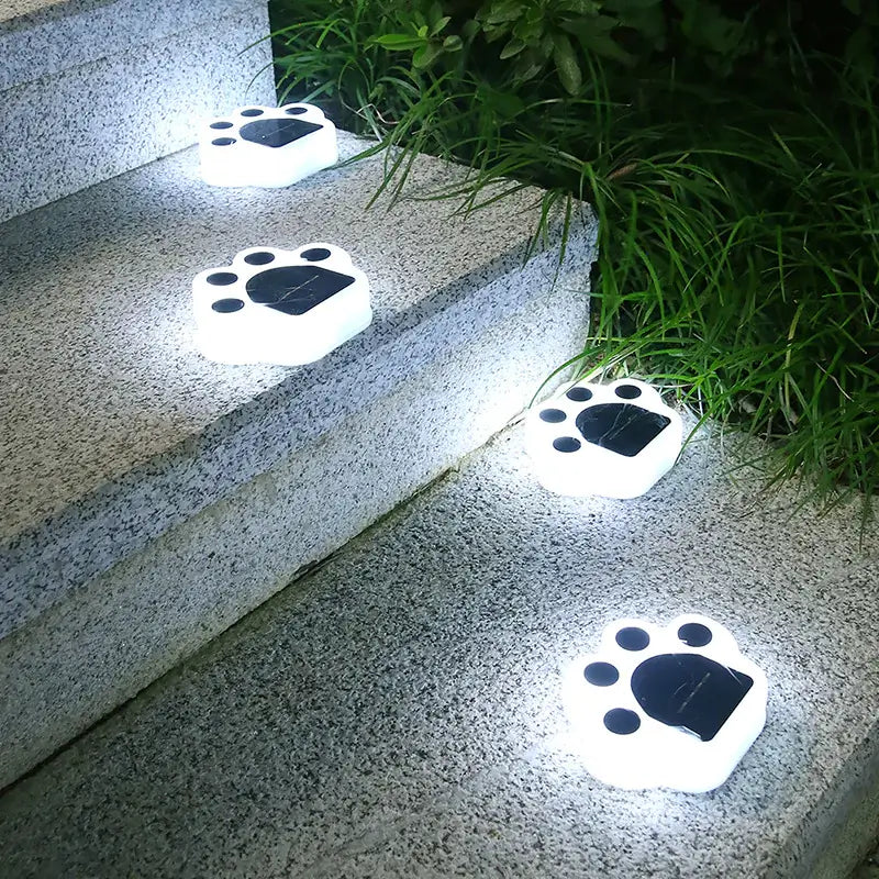 Solar LED paw print lights illuminating outdoor steps at night, enhancing safety and decor.