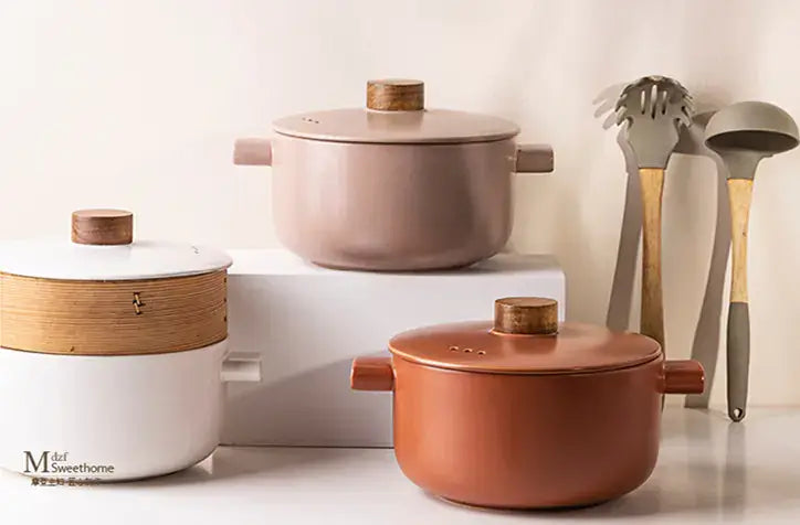 Elegant Morandi high-temperature porcelain casseroles in various colors with wooden lids and kitchen utensils.