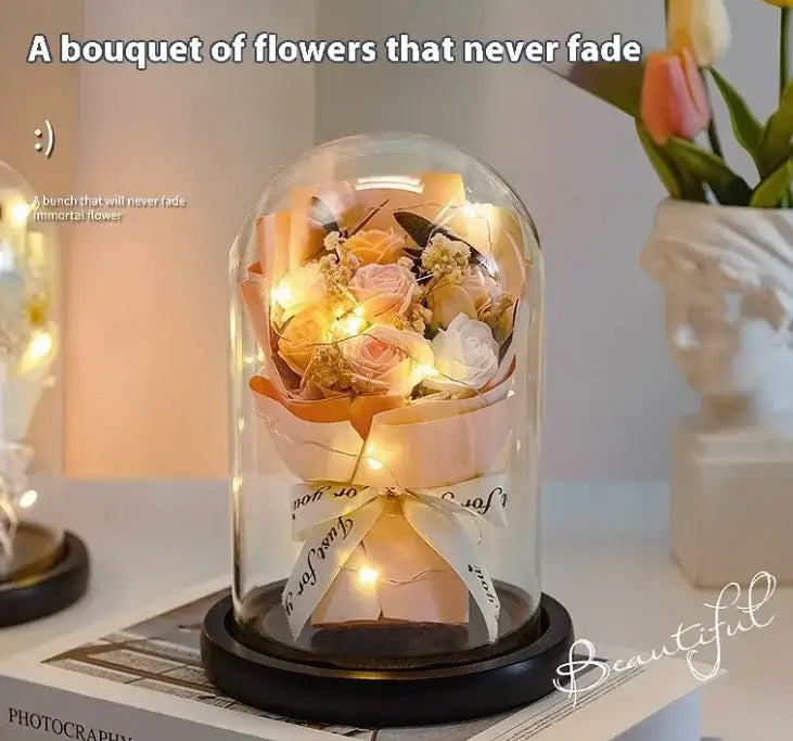 Elegant eternal rose display under glass dome with LED lights, showcasing preserved flowers in soft hues.