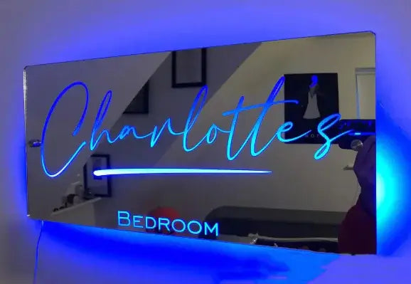 Custom LED light-up mirror with blue glow, featuring the name 'Charlottes' and the word 'Bedroom' for personalized decor.